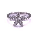 A French diamond cluster ring, composed of a star shaped flowerhead set with ten claw mounted