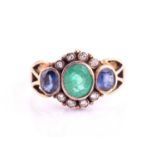 An Emerald and Sapphire dress ring, consisting of a central rub-over set oval emerald measuring