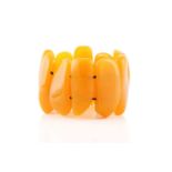 An egg yolk amber panel bracelet; of ten shaped oval and rectangular panels. 100 grams
