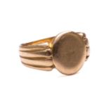 A Victorian signet ring in 18ct yellow gold, with a blank oval ring head to reeded shoulders and