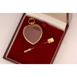 A 9ct yellow gold heart pendant and tie pin; the thick glass has been fitted into a heart-shaped