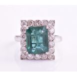 An emerald and diamond halo ring, consisting of a central emerald approximately measuring 10.9 x 8.7