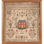 A George III woolwork sampler, with the alphabet over a house surrounded by trees and pots of