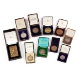 A collection of ten silver, white metal and bronze presentation medallions, comprising a silver gilt