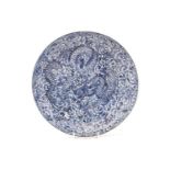 A Chinese porcelain 'Dragon' dish, painted with a writhing and snarling dragon amongst tightly