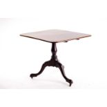A George III mahogany rectangular topped snap top tripod table with baluster column and cabriole