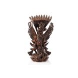 A Balinese-carved and pierced hardwood figure of Vishnu riding on his mount; the winged Garuda,