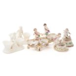 A pair of Berlin salts, each with a putto standing over two bowls and scrolling feet painted with