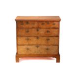 A Queen Anne walnut and deal chest of two short over three long drawers, with a quarter veneered