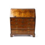 A George II walnut fall front writing bureau with a simple fitted interior enclosed by a book-