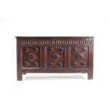 An 18th century oak triple panelled coffer, the panelled hinged lid over a fluted frieze and