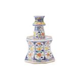 A Chinese porcelain altar candle stick of panelled-waisted form painted in Doucai enamels with