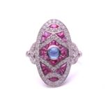 An art deco style oval panel ring set with a Sapphire and Rubies, the central cabochon Sapphire