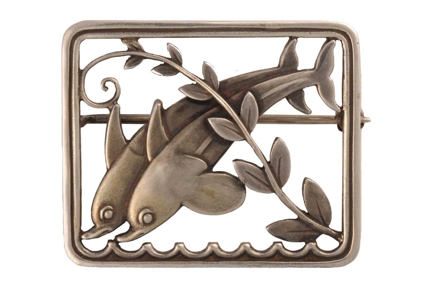 Georg Jensen - A silver 'double dolphin' brooch, depicting two dolphins with a fern motif across