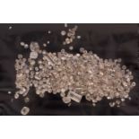 A melee of mixed cut loose diamonds including baguette cuts, old cuts, round brilliant and old