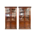 A near pair of Mid-Victorian mahogany bookcases, the moulded protruding cornices over pairs of
