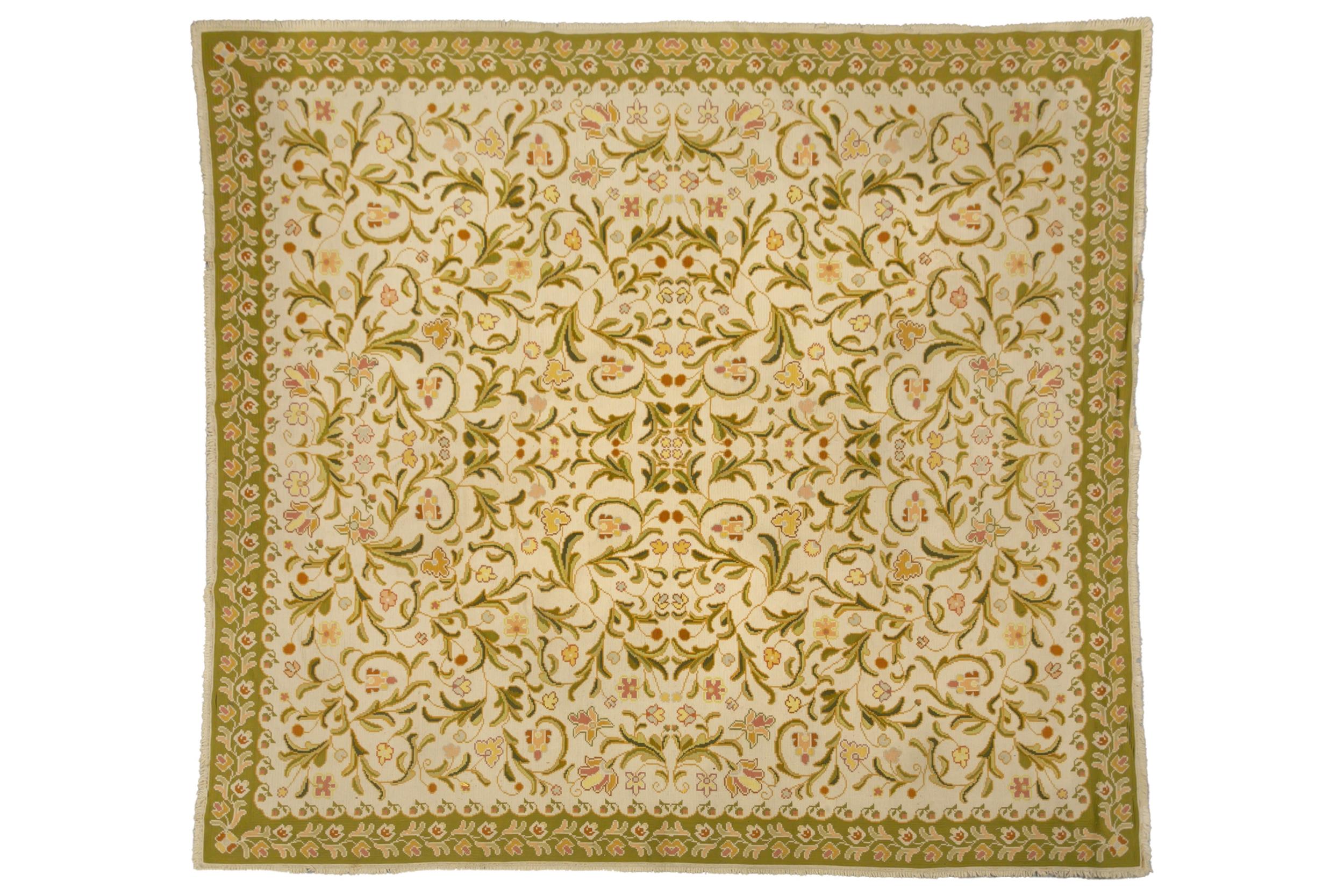 A large probably Indian flat woven Dhurrie-type carpet with iron red and sage green flowering shrubs