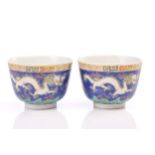 A pair of Chinese porcelain dragon tea bowls, the exterior painted with two opposing dragons