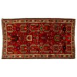 A crimson ground (Western(?)Turkish rug with a colourful geometric device filled field within,