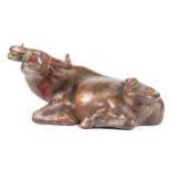 A Chinese bronze figure of a recumbent water buffalo, with traces of gilding and red pigment