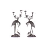 A pair of Japanese bronze two branch candelabra, late Meiji/Taisho period, modelled as a