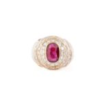 A ruby and diamond dress ring, containing an oval faceted ruby in dark purplish-red colour,