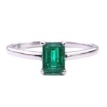 An emerald solitaire ring, featuring an emerald-cut emerald with intense green body colour,