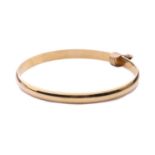 An 18ct yellow gold closed bangle, with a solid D-profile band, with London import marks and