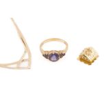 A 9ct yellow gold and purple gemstone ring, the round chequerboard-faceted central stone flanked