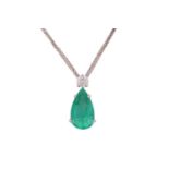 An emerald and diamond pendant on chain, featuring a pear-cut emerald with bright green body colour,