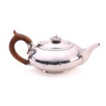 A George IV silver teapot, the lid with a lobed finial above a compressed body with traces of a