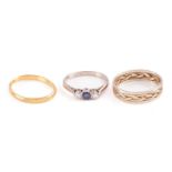 Three gold rings; including a 22ct yellow gold distorted wedding band, Birmingham hallmarked '22',