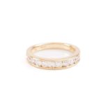 A diamond half-eternity ring in 18ct yellow gold, channel-set with thirteen graduated brilliant-