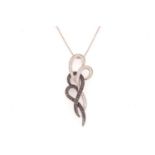 A white and black diamond pendant on chain, of scrollwork design, white and black oxidised mount,