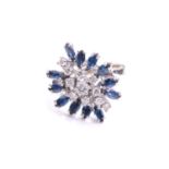 A sapphire and diamond cluster ring, the navette-shaped cluster comprises circular-cut diamonds