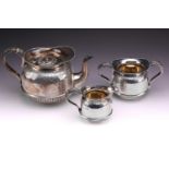 An Edwardian three piece silver tea set; circular with engraved acanthus band to upper body, band to