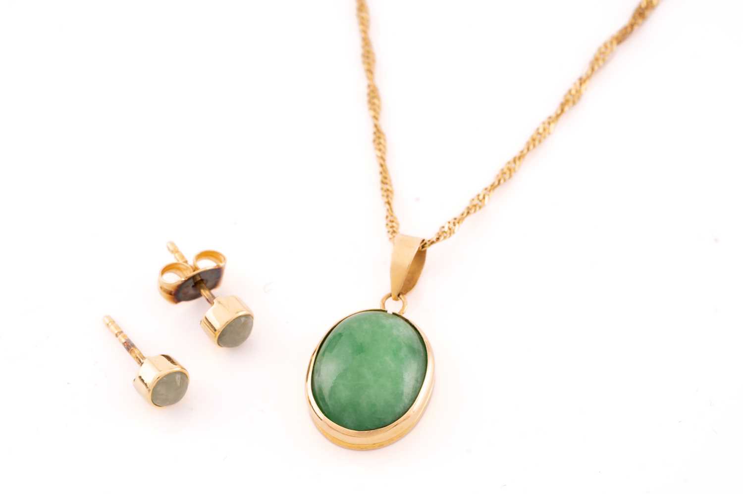 A jade pendant on chain with a pair of stud earrings in 18ct yellow gold; the pendant contains an