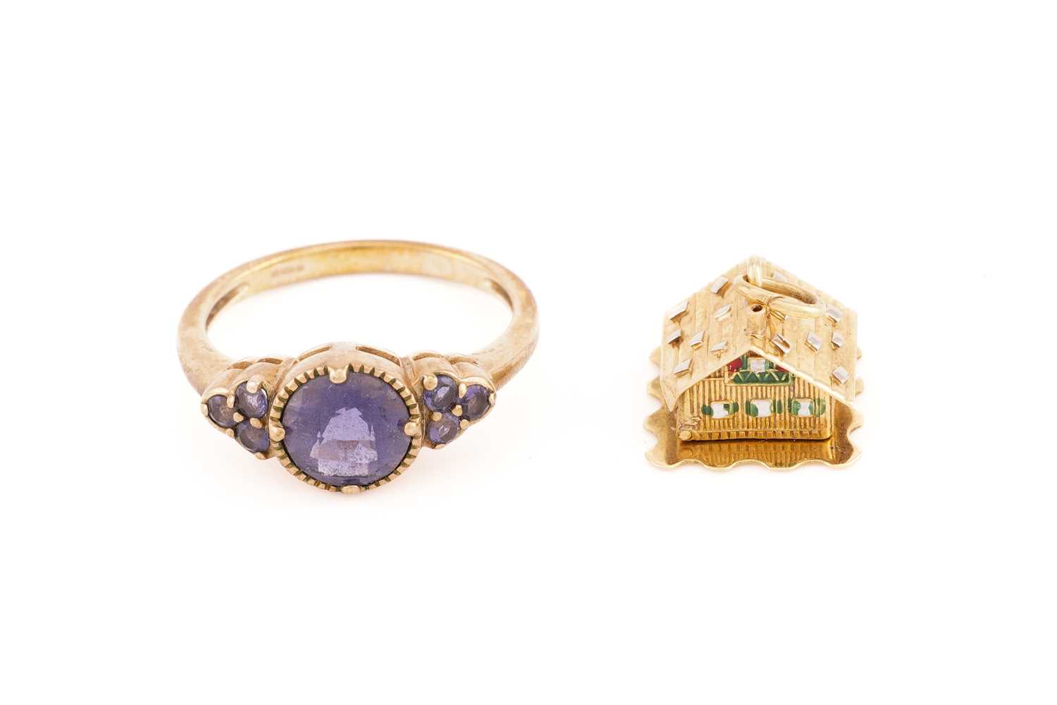 A 9ct yellow gold and purple gemstone ring, the round chequerboard-faceted central stone flanked - Image 2 of 9