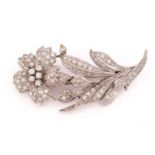 A flower brooch set with diamonds, the realistically modeled spray scintillating with circular-cut