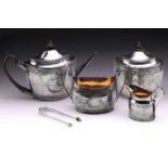 A matched four-piece George III silver tea set, including a tea caddy; oval with foliate bright cut