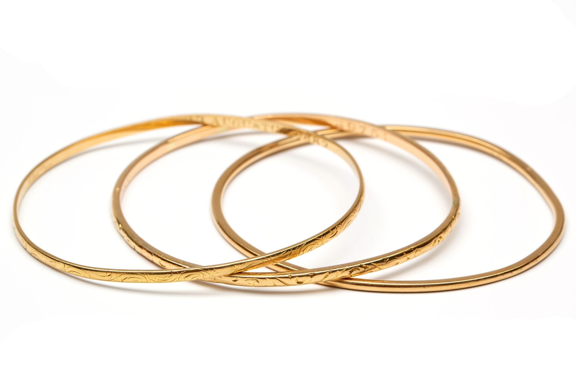 Set van drie 18 kt. gouden rinkelarmbanden,