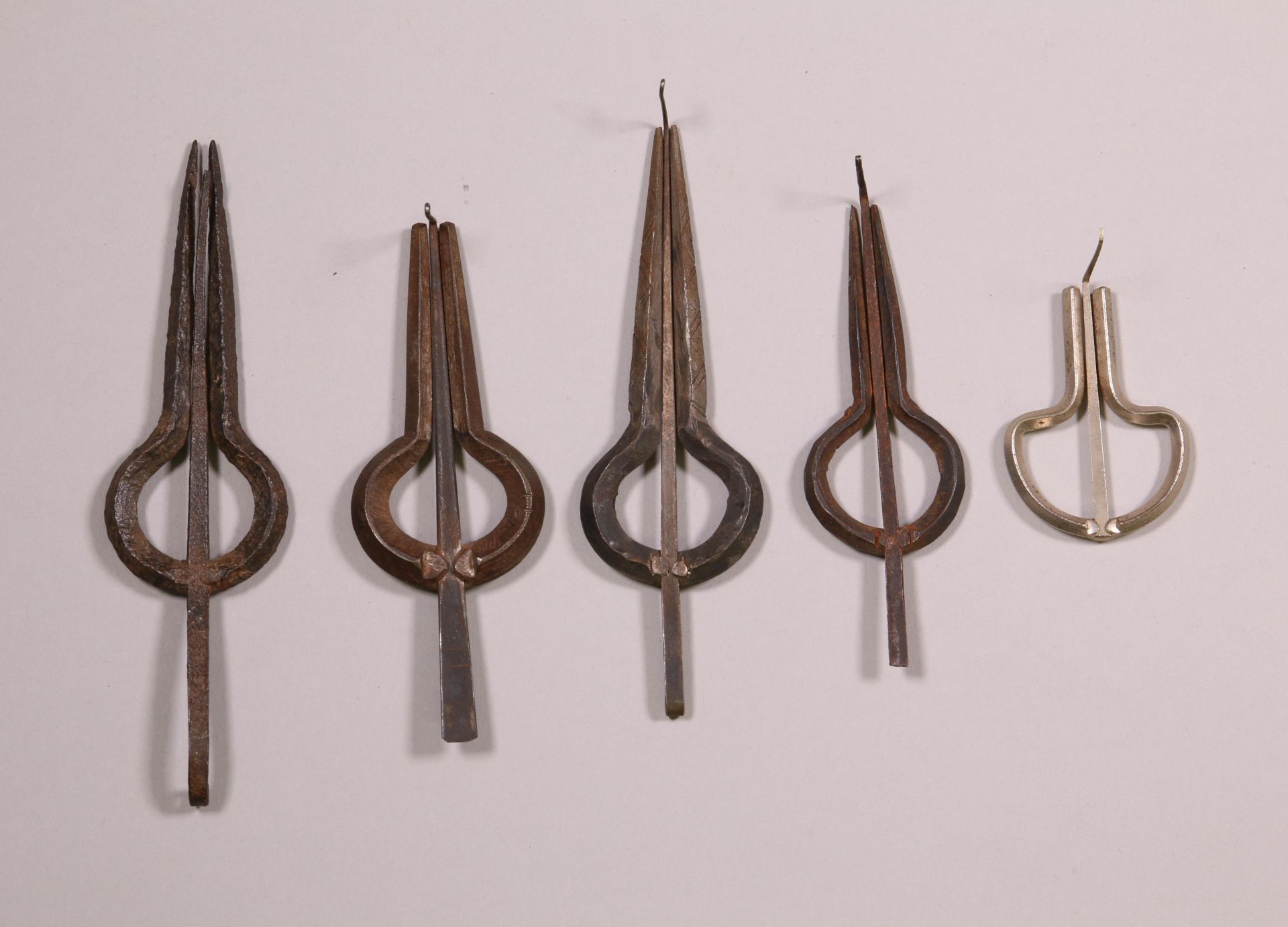 A collection of five metal mouth harps