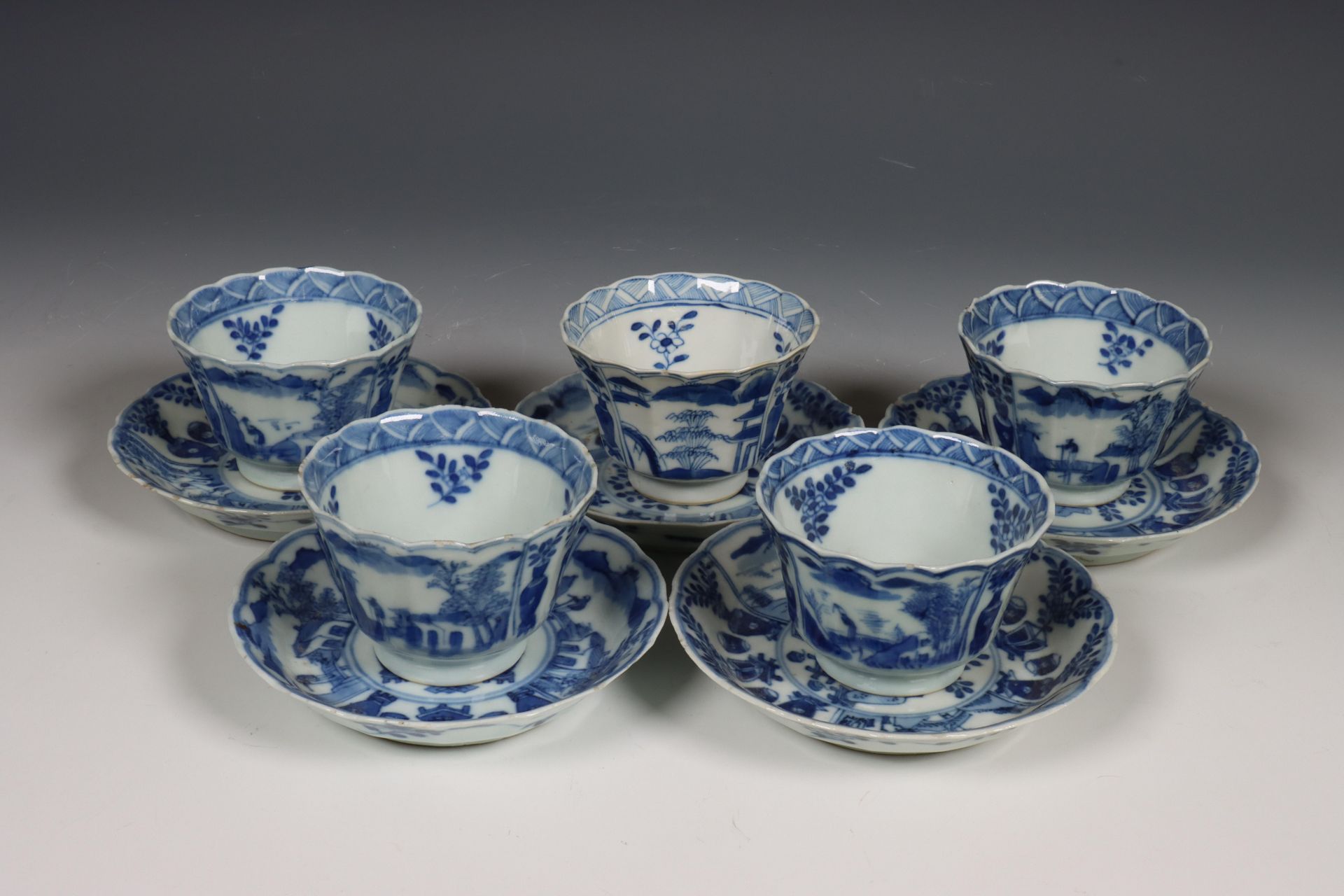 China, set van vijf blauw-wit porseleinen koppen en schotels, 18e eeuw,