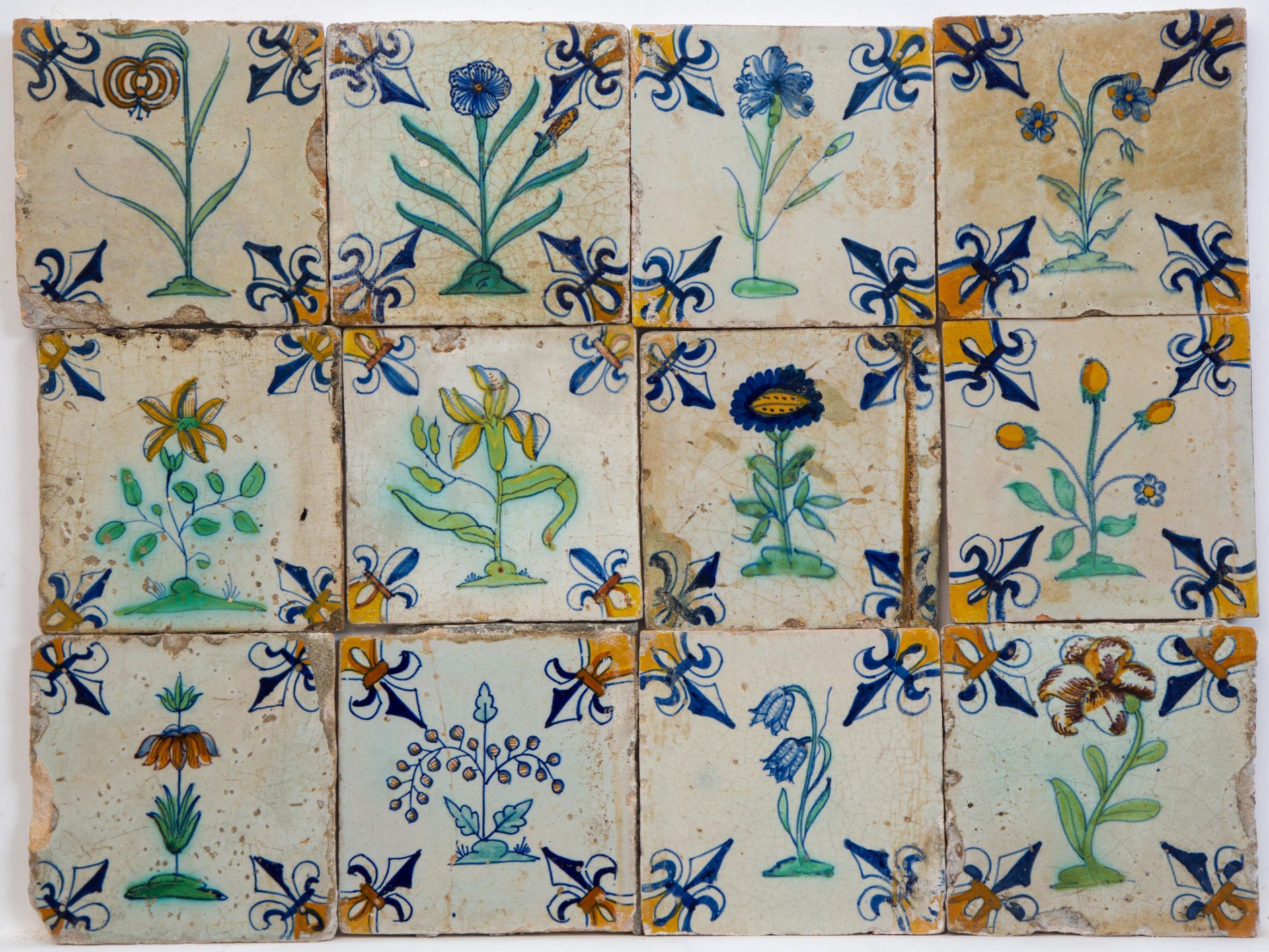 Twaalf polychroom aardewerk bloemdecortegels, eerste helft 17e eeuw;