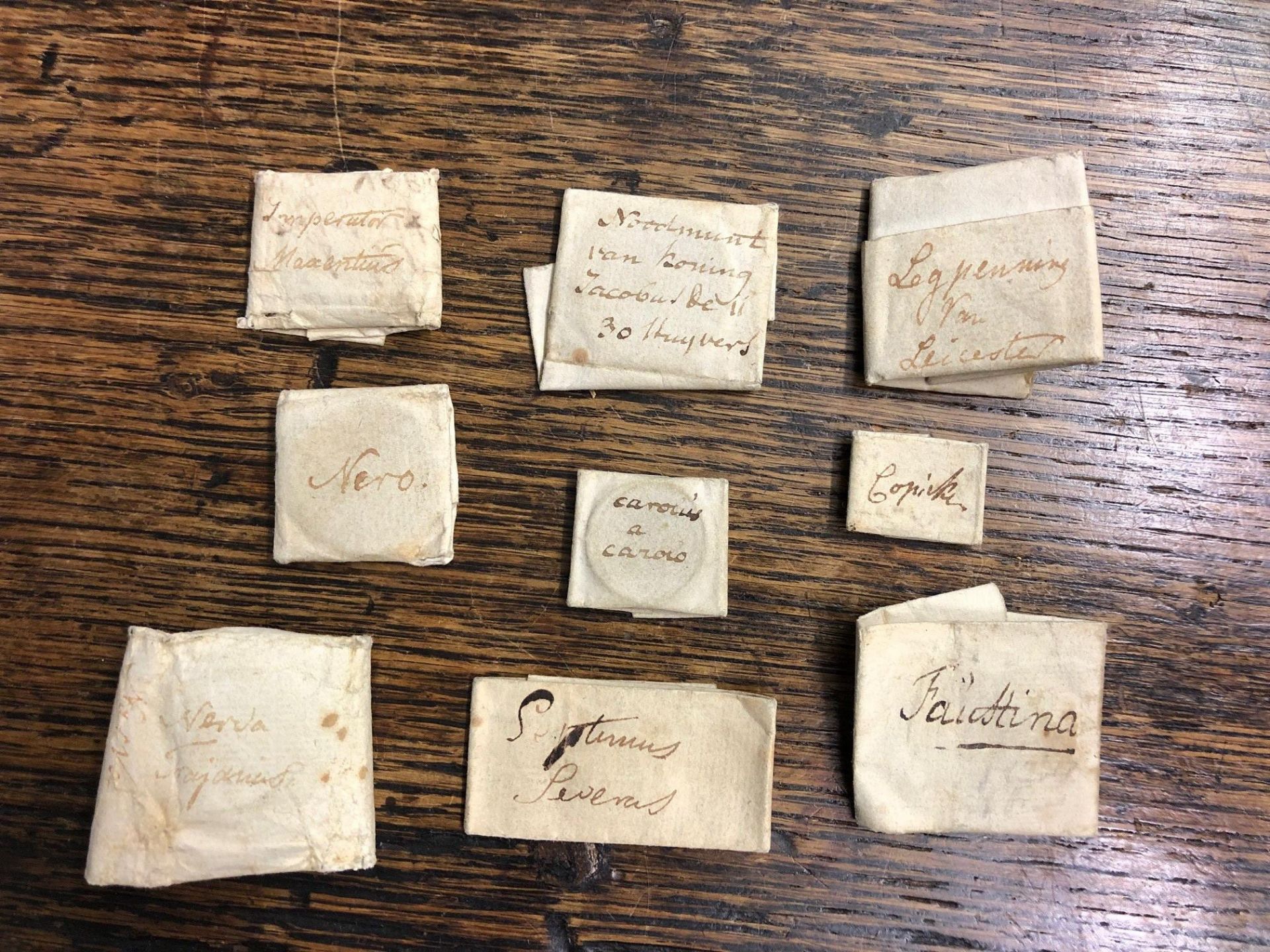 A 19th century collection of eleven Roman bronze copper alloy coins, wrapped in paper with comments - Image 2 of 3