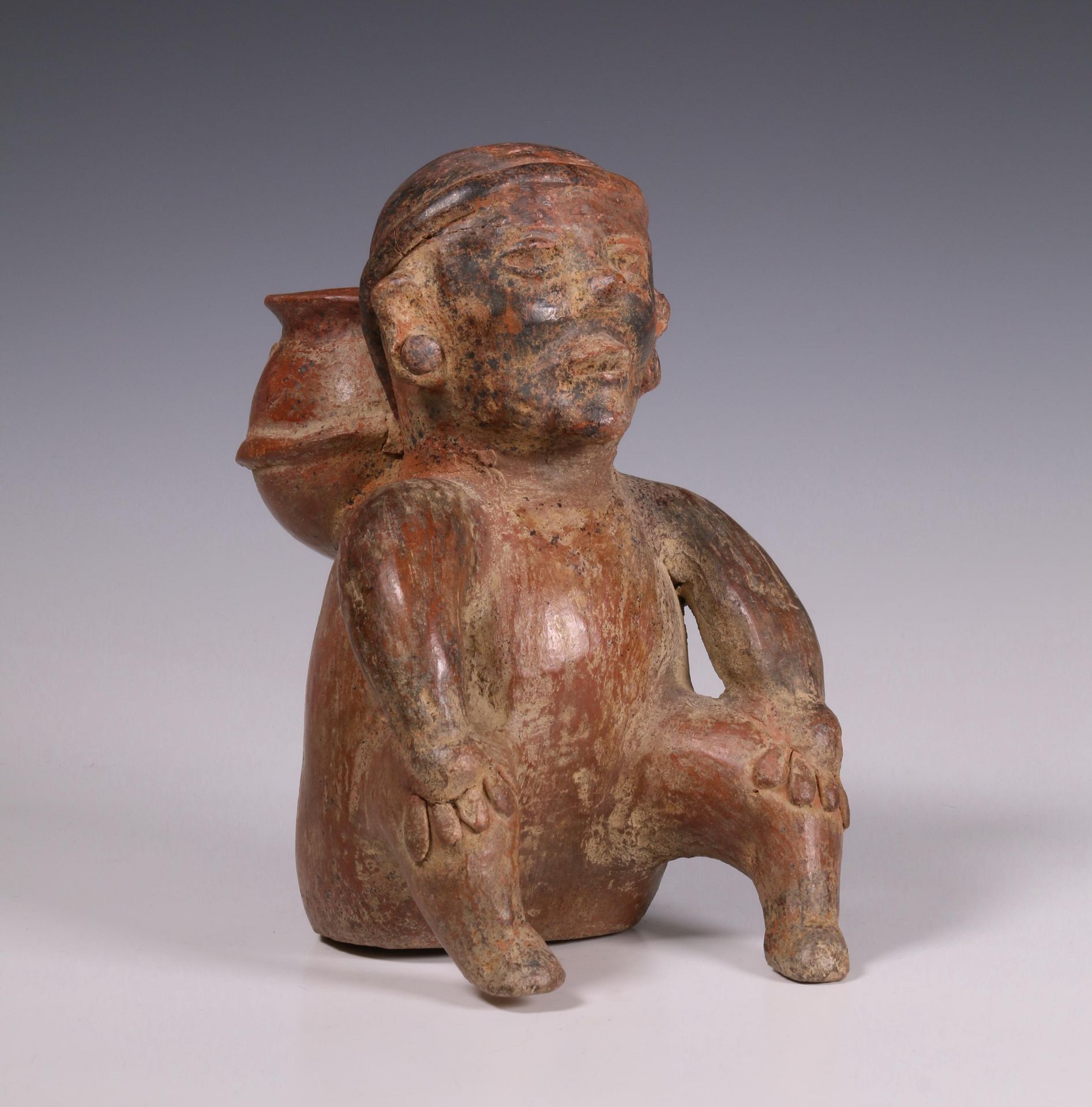 Mexico, Colima, a red earthenware sculpture of a seated figure, 100 BC-250 AD;