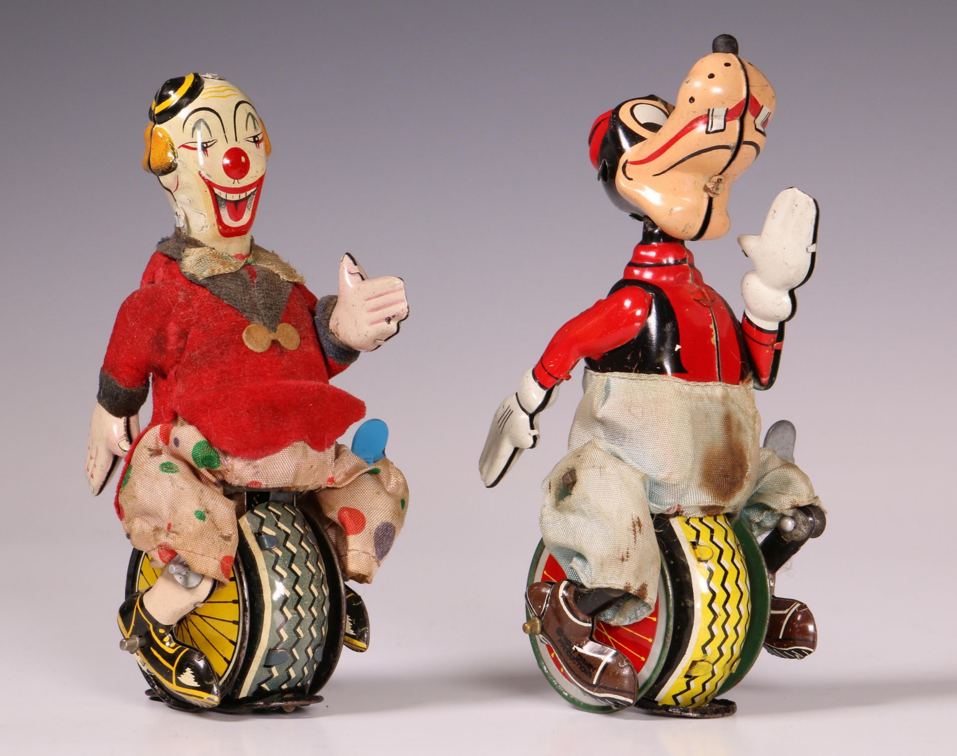 Japan, twee stuks blikken speelgoed, clown en goofy op eenwieler.
