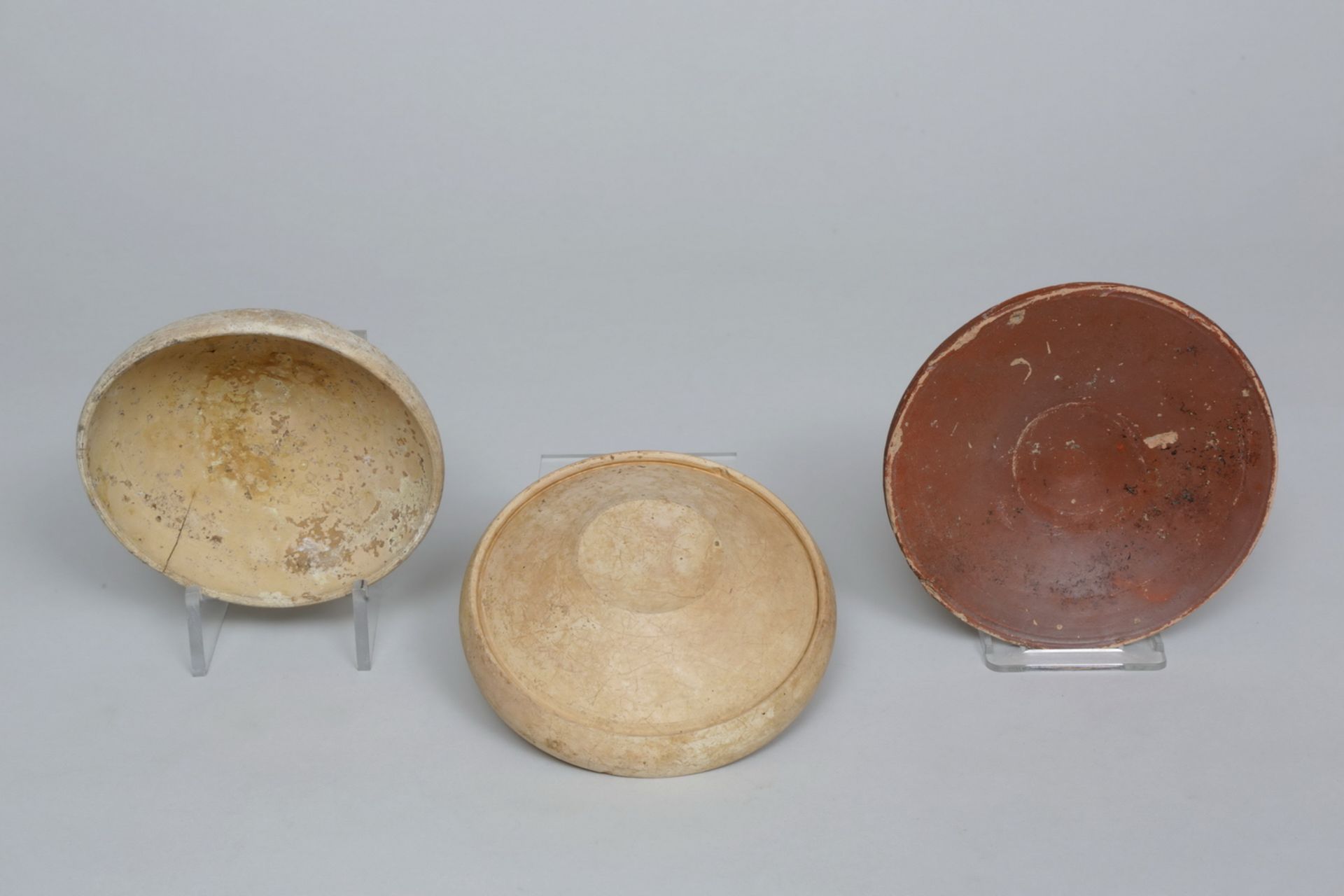 Etruscan, two earthenware dishes, 3rd century BC and a Roman, earthenware dish, ca. 3rd century.