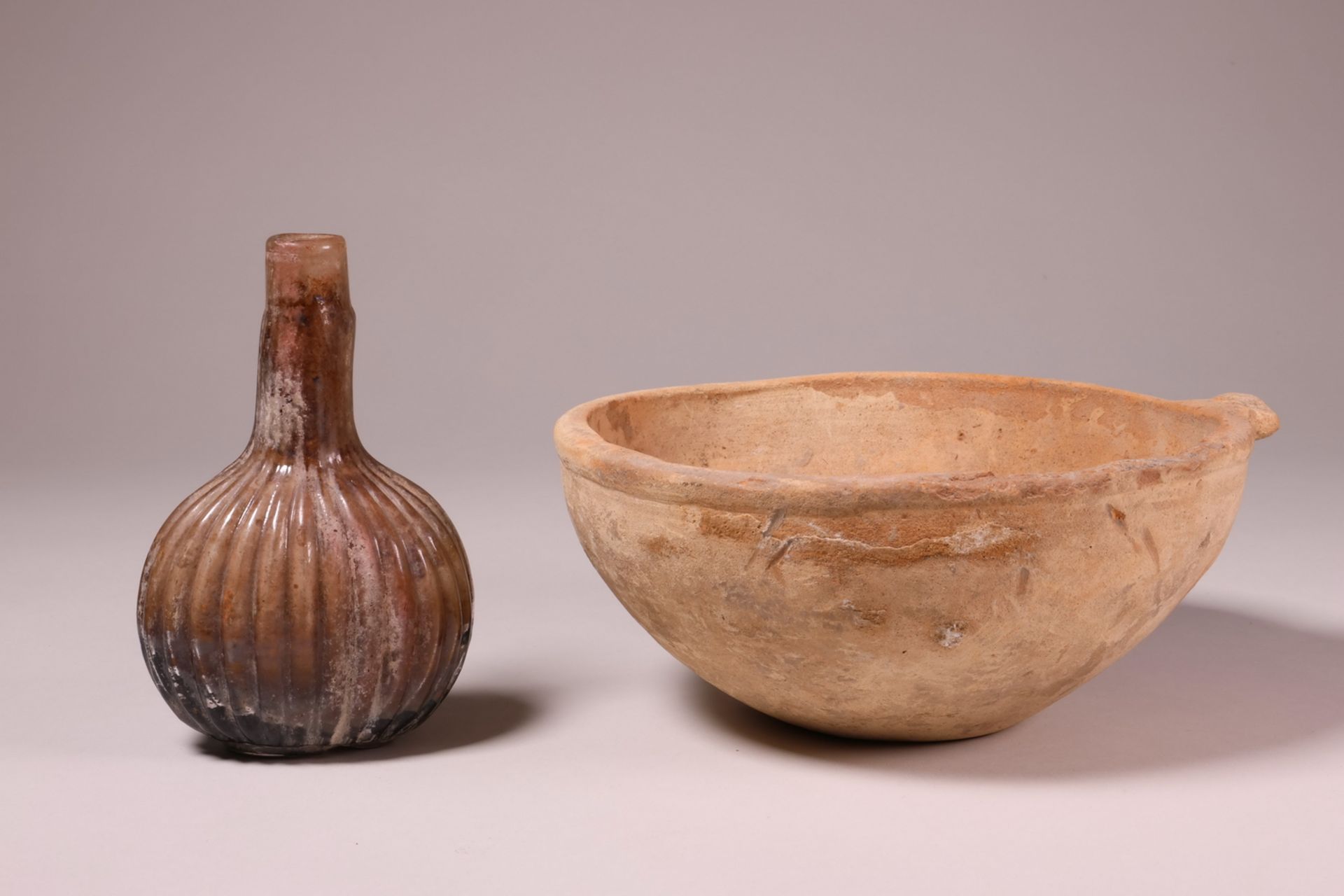 An antique terracotta bowl, possibly Roman and an antique glass flacon