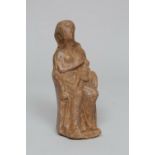 A impasto votive statue of a breast feeding seated female figure, possibly Etruscan, 4th - 3rd centu